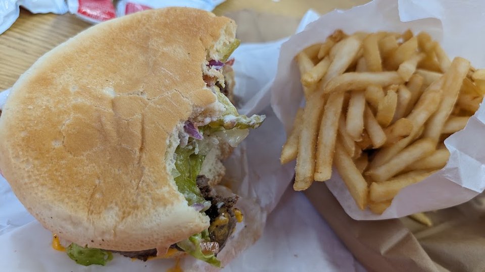 Printed menu showing burgers, salads, and shakes.