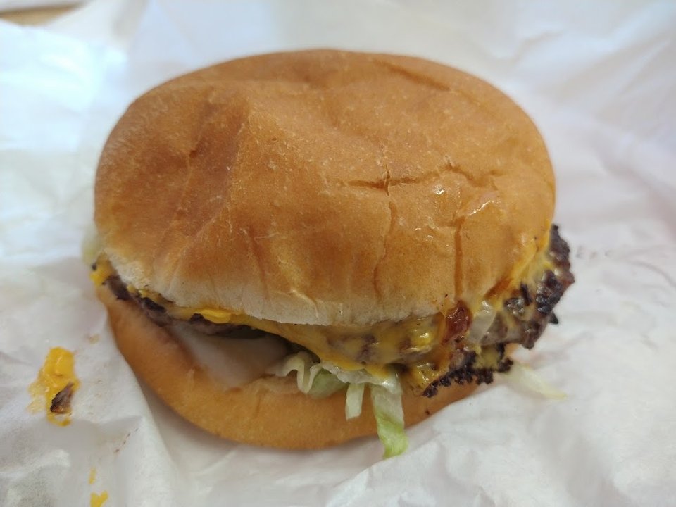 Printed menu showing burgers, salads, and shakes.